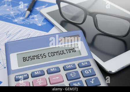 BUSINESS CONSULTING concetto calcolatrice sul tavolo con forniture di ufficio. ipad Foto Stock