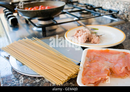 Preparare gli spaghetti integrali con salmone affumicato e salsa di pomodoro Foto Stock