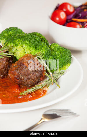 Le polpette di carne con salsa di pomodoro servita con broccoli e insalata di contorno Foto Stock