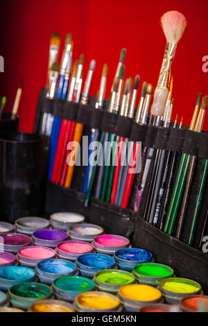 Vernice colorata di tubi e spazzole usate per il viso pittura Foto Stock