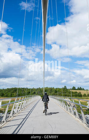Ciclista femmina sulla Infinity ponte che attraversa il Fiume Tees a Stockton on Tees vicino a Middlesbrough, Inghilterra del nord est. Regno Unito Foto Stock