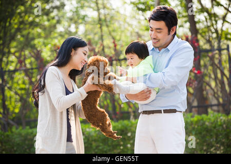 Felice giovane famiglia cinese con il loro cane Foto Stock