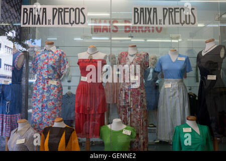 Prezzi bassi per la seconda mano womens' vestiti all'interno di una finestra del negozio a Porto, Portogallo. Foto Stock