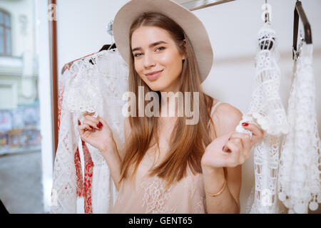 Ritratto di Allegro piuttosto giovane donna facendo shopping nel negozio di abbigliamento Foto Stock