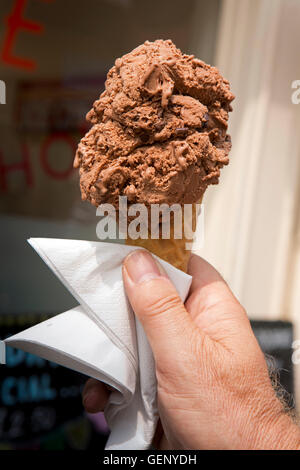 Regno Unito, Inghilterra, Devon, Sidmouth, mano azienda grande cioccolato gelato in cono di wafer Foto Stock