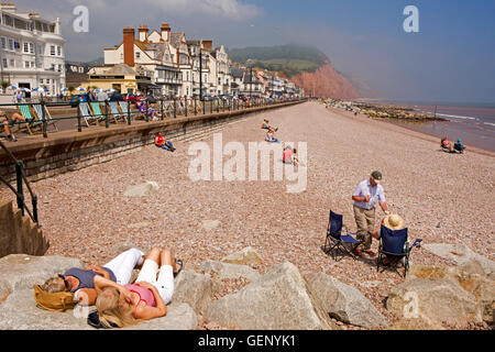 Regno Unito, Inghilterra, Devon, Sidmouth, Esplanade, visitrs sulla spiaggia nella luce del sole Foto Stock