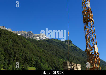 Una fotografia di una gru da cantiere nella regione alpina della Svizzera. Foto Stock