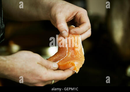 In prossimità di uno chef tenendo un pesce fresco filetto. Foto Stock