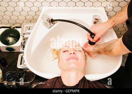 Una donna con capelli corti presso i parrucchieri Foto Stock