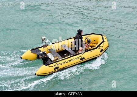 Un uomo alla guida di un St Ives self drive noleggio barca in mare Cornwall Inghilterra Regno Unito Foto Stock