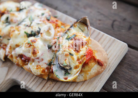 Pizza con frutti di mare su uno sfondo di legno cibo italiano Foto Stock