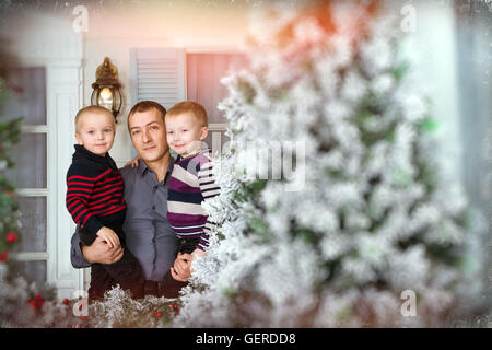 Padre amorevole con i suoi due figli in posa per un giunto verticale. 19 giugno - una vacanza internazionale la festa del papà. Family photo shoot Foto Stock