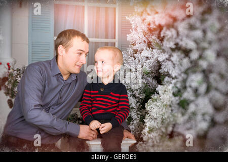 Padre amorevole con suo figlio in posa per un giunto verticale. 19 giugno - una vacanza internazionale la festa del papà. Family photo shoot Foto Stock