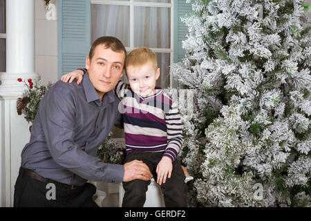 Padre amorevole con suo figlio in posa per un giunto verticale. 19 giugno - una vacanza internazionale la festa del papà. Family photo shoot Foto Stock