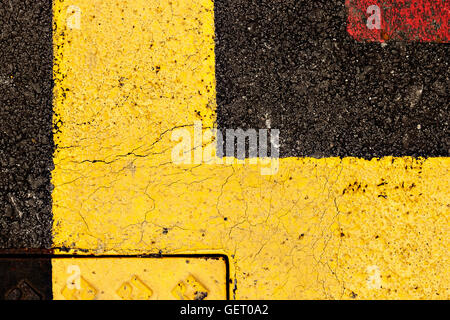 Asfalto dipinte di giallo e rosso, adatto per texture di sfondo astratto. L'immagine orizzontale. Foto Stock