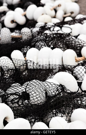 Nero a rete da pesca con tappi bianchi nel porto di Santona, Cantabria, Spagna. L'immagine verticale. Foto Stock