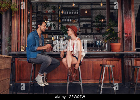 Colpo di coppia giovane seduto presso il cafe contatore. Giovane uomo e donna presso la caffetteria. Foto Stock