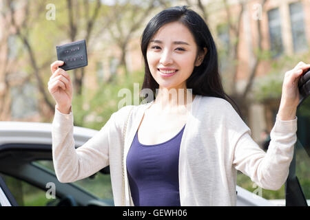 Giovane donna cinese che mostra la sua patente di guida Foto Stock