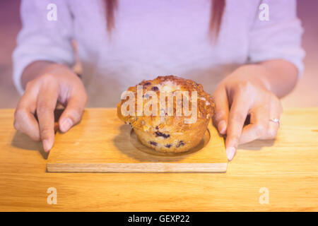 Giovane donna holding muffin alla banana Foto Stock