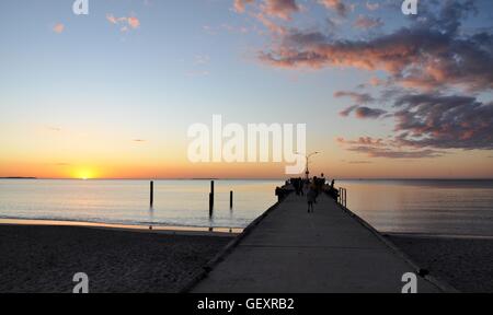 Jetty nella diminuzione della prospettiva con calma le acque dell'Oceano Indiano e arancione tramonto a Coogee Beach a Coogee,l'Australia Occidentale Foto Stock