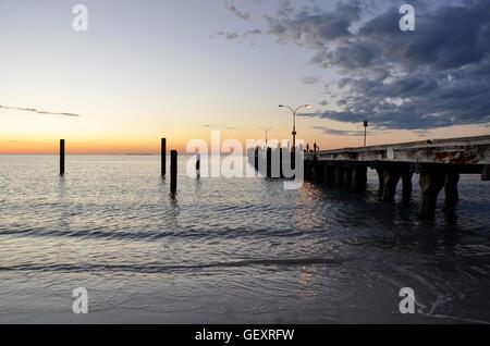 Coogee,WA,Australia-October 25,2015:Oceano Indiano con jetty, palificazioni e fisherman in silhouette sotto un cielo di tramonto a Coogee, Western Australia. Foto Stock