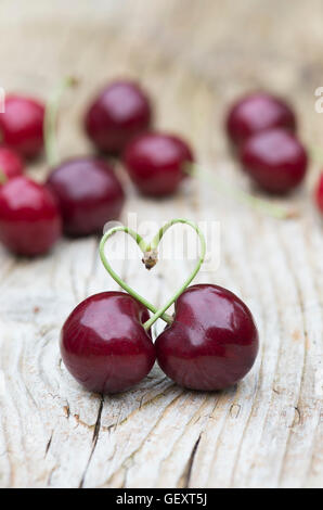 Le ciliegie raccolte amore cuore su legno Foto Stock