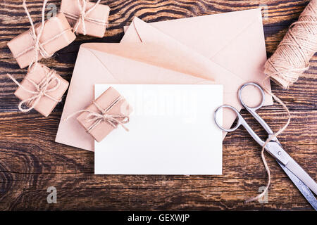 La busta e la scheda vuota per le vacanze messaggio sullo sfondo di legno, artigianato set decorazioni fatte a mano visto dal di sopra Foto Stock