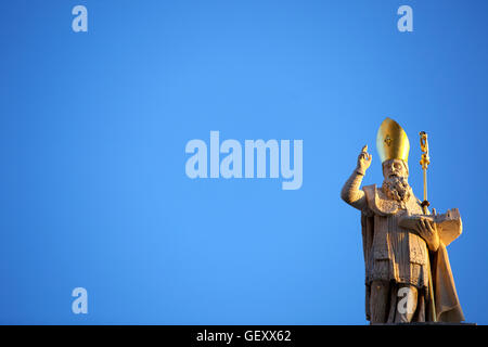 La statua di San Biagio sul tetto della chiesa di San Biagio contro un cielo blu chiaro. Foto Stock