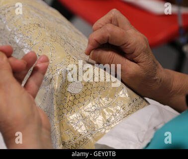 Le mani degli anziani mentre il ricamo di un pizzo a Venezia in Italia Foto Stock