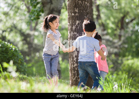 Felici i bambini cinesi a giocare nei boschi Foto Stock