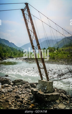 Danneggiato ponte sopra il Bhote khosi fiume, che scorre attraverso la bella valle di montagna nelle montagne del Nepal Foto Stock