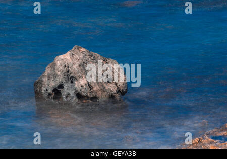 Grande roccia circondato da seta acqua sfocata sulla costa di Corralejo, Fuerteventura, Isole canarie, Spagna Foto Stock