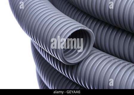 Tubo corrugato per l'installazione di cavo elettrico isolato su sfondo bianco Foto Stock