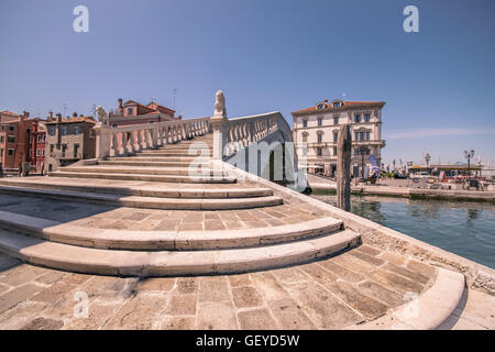 Tipico ponte attraverso un canale di Chioggia, Laguna Veneziana, Italia. Foto Stock