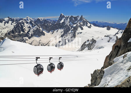 Turisti che si godono il paesaggio maestoso in gondole dalla Punta Helbronner a Aiguille du Midi, Francia Foto Stock