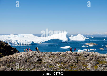 Persone su un sentiero escursionistico al punto di vista Nakkaavik affacciato sulla baia di Disko con gli iceberg da Ilulissat icebergs offshore. Ilulissat Tourist Nature Groenlandia Foto Stock