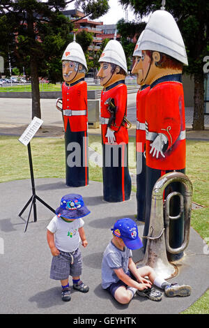 Militari di Brass Band paracarri, artista Jan Mitchell, con piccole ragazzi giocare su waterfront park a Geelong, Victoria, Australia Foto Stock