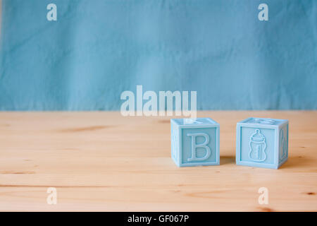 Blue Baby blocchi su di un blu e lo sfondo di legno. Foto Stock