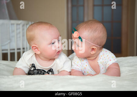 Twin baby un ragazzo e una ragazza si trovano sul letto Foto Stock