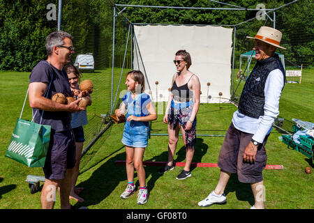 Una famiglia vincere diversi Noci di cocco dopo la riproduzione sul noce di cocco timido, Withyham Fete, Withyham, Sussex, Regno Unito Foto Stock