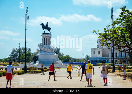 Un gruppo di uomini a Giocare calcio di strada vicino alla statua del generale Máximo Gómez a l'Avana, Cuba. Foto Stock