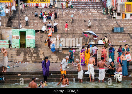 Una folla di persone che compiono il loro mattina rituale di purificazione sul ghats del Fiume Gange, Varanasi, Uttar Pradesh, India Foto Stock