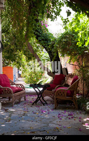 Garden Lounge con cuscini rossi - posto rilassante ombreggiato nel Bodrum Hotel Garden Foto Stock