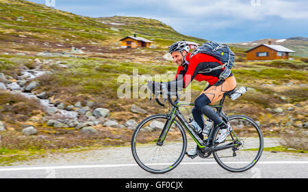 Ciclista pedala sulla Route 7, Parco Nazionale di Hardangervidda in primavera. Norvegia Hordaland, Scandinavia, europeo Foto Stock