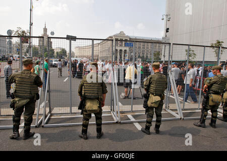 Kiev, Ucraina. 27 Luglio, 2016. I soldati della guardia nazionale stare vicino alla recinzione metallica come credenti di ucraini Chiesa Ortodossa del Patriarcato di Mosca si riuniscono per celebrare l'anniversario del Battesimo di Kievan Rus a Kiev, il 27 luglio 2016. I sostenitori della chiesa ortodossa ucraina di Kiev il Patriarcato credono che la processione della croce è organizzata da pro-russo il potere di destabilizzare la situazione politica nel paese © Vasyl Shevchenko/ Pacifico premere/Alamy Live News Foto Stock