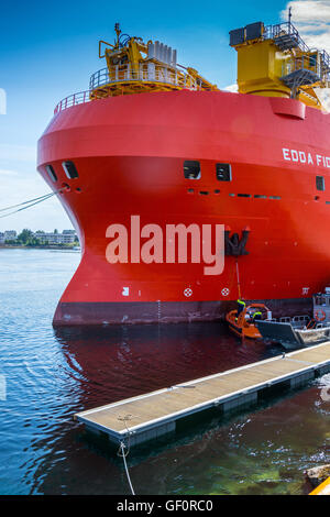 Edda Fides flotel, alloggio nave per l'industria petrolifera, big red nave due uomini di pulizia con spazzola lunga Foto Stock