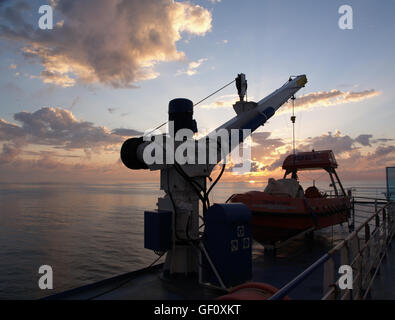 Tramonto dal ponte principale di Minoan Lines nave traghetto Cruise Olympia Ancona, Italia per Igoumenitsa Grecia scialuppa di salvataggio in primo piano Foto Stock