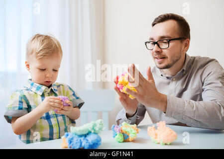 Padre e figlio giocare con argilla a sfera a casa Foto Stock