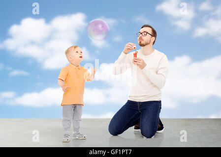 Padre con figlio soffiare bolle e divertirsi Foto Stock