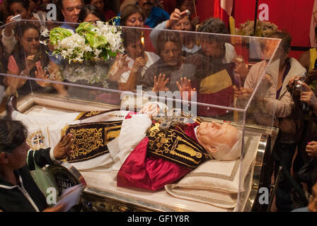 I cattolici la linea fino a passare e toccare la superficie esterna del vetro-racchiuso effigie e reliquie di Papa Giovanni Paolo II. Foto Stock